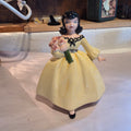 Ceramic girl in yellow w/flowers
